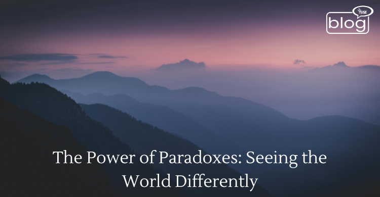 A serene mountain silhouette at dusk, with soft purple and blue hues. Text overlay: "The Power of Paradoxes: Seeing the World Differently."
